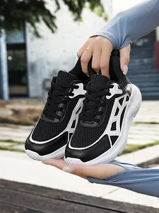 Detail of breathable black mesh running shoes with lightweight thick white soles.