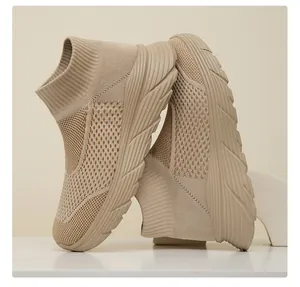 Detail view of breathable beige fly-knit high-top sock sneakers with a thick sole.