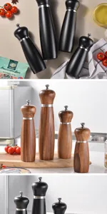 Detailed view of black matte and acacia wood manual pepper grinders in a kitchen setting