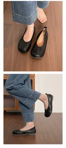 Detailed view of women's black soft leather Tabi-style ballet flats shown on a wooden floor