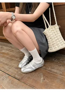 Dettaglio di scarpe stile balletto argento con mesh traspirante e chiusure a strappo