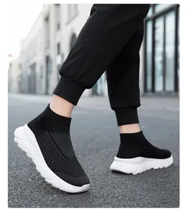 Close-up of lightweight black high-top knit sock sneakers worn during walking outdoors.