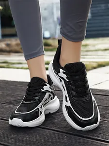 Close-up of men's black breathable mesh sneakers with thick white soles on-feet
