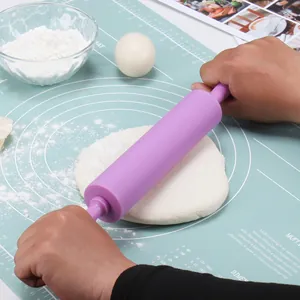 Professional purple silicone rolling pin with ergonomic handles on a non-stick baking mat