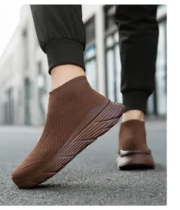 Side view of brown high-top sock sneakers with thick textured soles on street pavement.