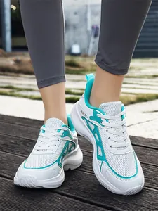 Detailed view of breathable white mesh sneakers with teal accents and thick sole