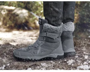 Detailed side view of grey winter snow boots with warm faux fur lining on outdoor ground