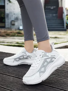 Detailed view of breathable white mesh sneakers with chunky sole and lace-up design.