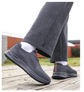 Vista laterale di comode scarpe da passeggio grigie da uomo su un ponte di legno esterno