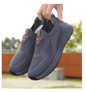 Vista ravvicinata dettagliata di sneaker slip-on in mesh grigio tenute in mano all'aperto