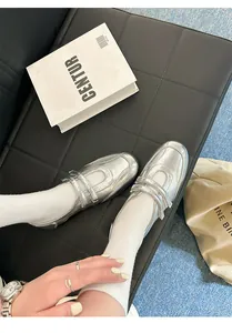 Detailansicht der silbernen Metallic-Mary-Jane-Schuhe mit Klettverschluss auf Leder