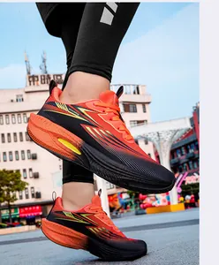 Close-up of lightweight orange and black running shoes with carbon plate soles