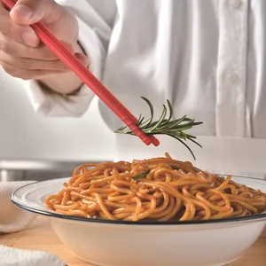 Bacchette professionali in silicone rosso per alimenti sopra una ciotola di spaghetti