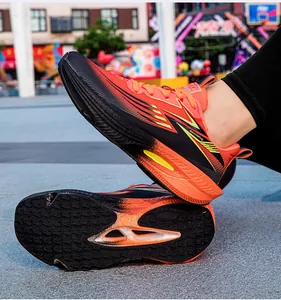 Close-up of vibrant orange gradient running shoes showing durable traction outsole detail.
