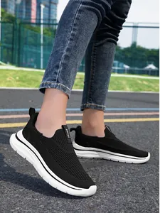 Detalle de cerca de zapatillas fly-knit negras de mujer con suelas blancas gruesas