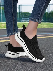 Primer plano de zapatillas negras de punto transpirable en una pista de atletismo