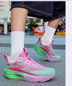 Close-up of vibrant pink and green gradient running shoes worn by a model outdoors.