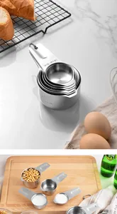Macro view of stainless steel measuring cups set with engraved measurement markings.