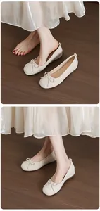 Close-up view of beige ballet flats with bow detail and hidden wedge on model feet.