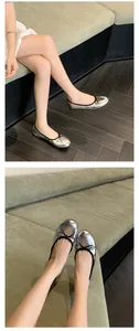 Nahaufnahme eleganter silberner Ballerinas mit schwarzer Schleife und runder Kappe am Modell