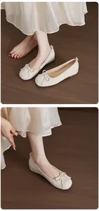 Elegant beige ballet flats with bow detail and hidden wedge shown on a model's feet