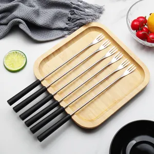 Set of 7 stainless steel fruit and dessert forks with black handles on a bamboo tray