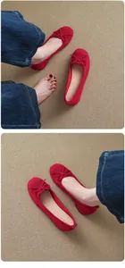 Red French style ballet flats with bow detail and round toe on carpet