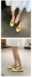 Detaillierte Ansicht gelber Ballerinas mit schwarzer Schleife und rundem Design