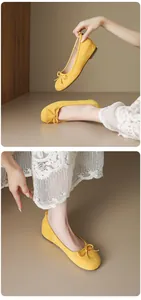 Close-up of yellow suede ballet flats featuring a delicate bow and round toe design
