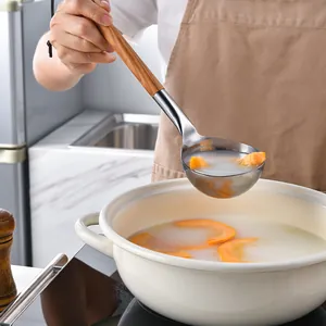 Cucharón de acero inoxidable con mango de madera de olivo en una cocina moderna