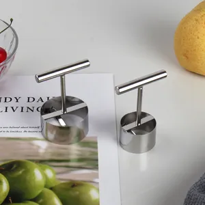 Professional stainless steel fruit corer tool for pears and apples on a minimalist table.