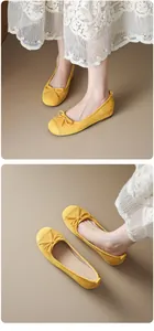 Close-up detail of yellow suede ballet flats with delicate bow and lace hem
