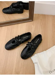 Detailansicht schwarzer Mary-Jane-Flachschuhe im französischen Stil mit Klettverschluss.