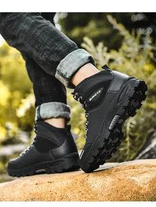 Gedetailleerd zijaanzicht van zwarte hoge wandelschoenen op een rotsachtig pad