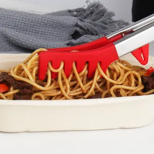Pince à spaghetti en silicone rouge avec manche en inox pour servir des pâtes d'un bol.