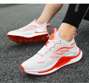 Nahaufnahme von weiß-orangen, atmungsaktiven Mesh-Laufschuhen auf einer Asphaltstraße