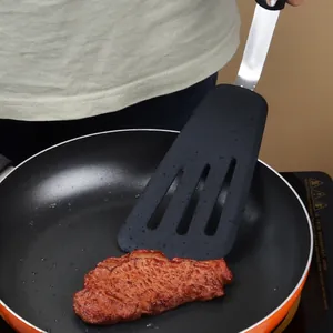 Espátula de silicona duradera con mango de acero inoxidable friendo filete en sartén