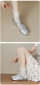 Detail view of silver Mary Jane flats showing cross straps and metallic leather finish