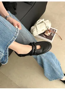 Detailansicht schwarzer Mary Jane Ballerinas mit Klettverschluss am Fuß des Models