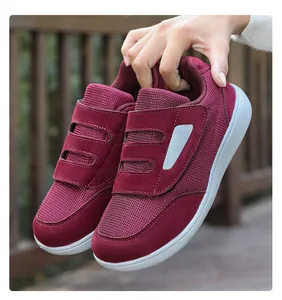 Detail of burgundy casual walking shoes featuring adjustable hook-and-loop straps.