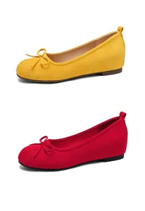 Close-up of French style bow ballet flats in yellow and red suede finish
