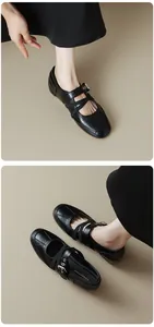Close-up detail of black vintage Mary Jane shoes featuring criss-cross straps and buckle