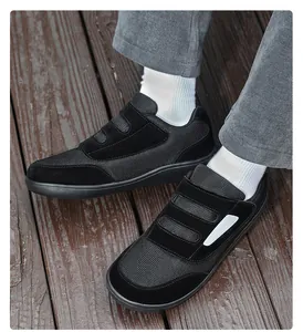 Detailed view of black velcro walking shoes featuring mesh and suede texture on feet