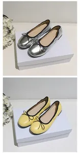 Detailansicht von silbernen und gelben Ballerinas mit schwarzen Schleifen und Paspeln