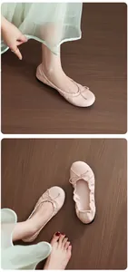 Close-up view of soft pink ballet flats featuring elegant bow details and flexible soles.