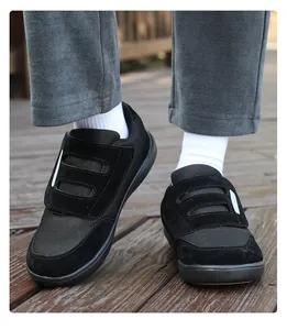 Close-up of black velcro walking shoes worn on a wooden deck with white socks