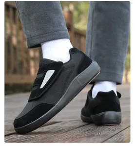 Detail view of black Velcro casual walking shoes for seniors shown on a wooden boardwalk