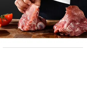 Close-up of a heavy duty high carbon steel bone chopper cutting raw meat on a board