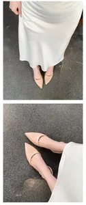 Close-up detail of French style nude pointed toe patent leather flat slingback shoes