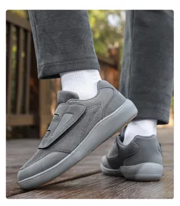 Detailed view of grey casual walking shoe with velcro closure on wooden deck.